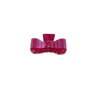 Magenta acetate bow hair claw clip with a glossy finish and vertical texture detail