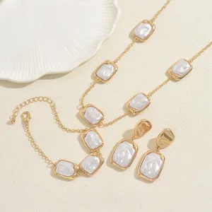 Retro gold jewelry set with rectangle pearl necklace and matching earrings on a shell tray