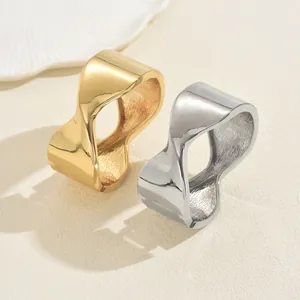 Minimalist geometric wave-shaped rings in gold and silver with polished mirror finish