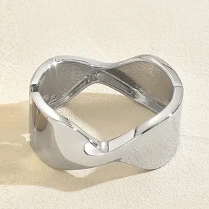 Detail of silver wavy wide bangle showing polished exterior and brushed interior texture