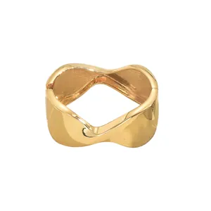 Minimalist golden wavy metal cuff bracelet with a polished finish and hinged closure
