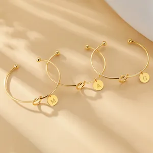 Adjustable gold open bangles featuring personalized alphabet letter round pendants