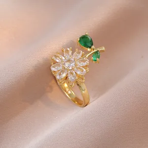 Golden daisy ring featuring white marquise zircon petals and green pear-shaped leaves