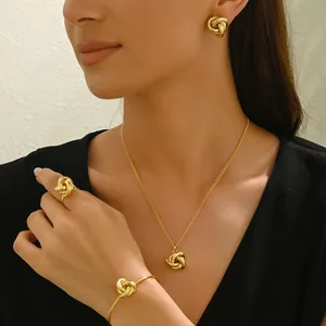 Gold twist jewelry set with necklace, earrings, ring, and open cuff on model