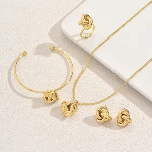 Elegant gold jewelry set with twisted knot necklace, ring, bangle, and stud earrings