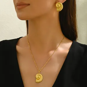 Parure collier et boucles d'oreilles pendentif coquillage doré porté par un mannequin