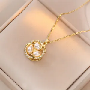 Elegant gold necklace featuring three pearls surrounded by zircon stones on a leather box