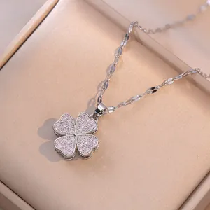 Silver chain necklace with pink zircon clover pendant on elegant champagne satin