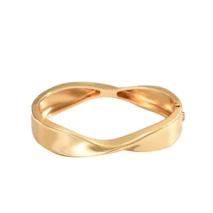 Eleganter goldener gedrehter geometrischer Armreif mit poliertem Metall-Finish und Verschluss