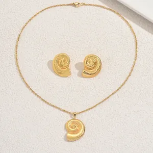 Détail macro d'un ensemble de bijoux spirale dorés avec collier et boucles d'oreilles