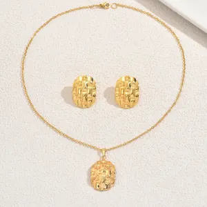 Détails de l'ensemble de bijoux dorés avec textures tissées sur les pendentifs
