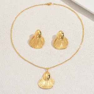 Vue détaillée de l'ensemble bijoux cœur doré avec texture plissée sur collier et boucles
