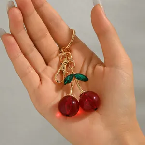 Cute cherry shaped keychain with gold metal ring and sparkling green crystal leaves