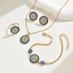 Set gioielli occhio greco dorato con collana orecchini anello e bracciale su sfondo bianco