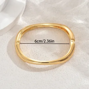 Polished 18k gold plated geometric oval bangle with 6cm inner diameter and side hinge
