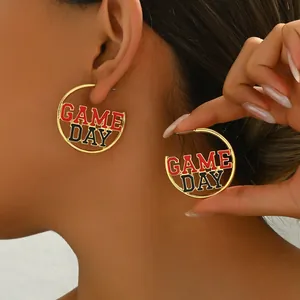 Golden round earrings featuring red and black enamel with GAME DAY letter design