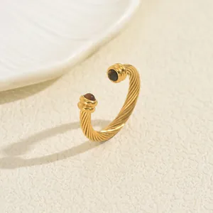 Goldener gedrehter Kabelring mit Türkissteinen in minimalistischem Flecht-Design