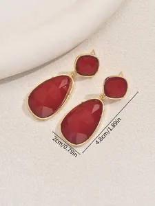 Macro shot of red teardrop gemstone earrings with gold base, size 2cm by 4.8cm