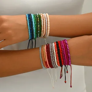 Détail de bracelets en perles colorées au poignet avec cordon réglable et cristaux