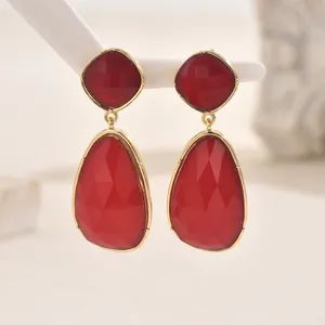 Elegant geometric drop earrings with red faceted stones in a golden metal frame