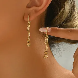 Detail of gold dangle earrings with champagne gradient crystals worn by a model