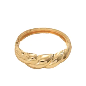 Elegante brazalete rígido de diseño trenzado dorado con acabado pulido y cierre seguro