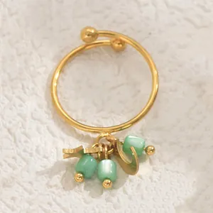 Detailansicht goldener offener Ring mit grünen Katzenaugenperlen und Stern-Mond-Anhängern