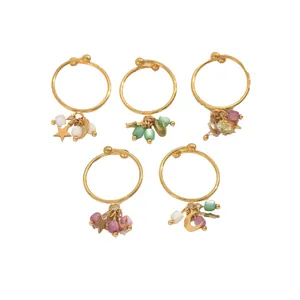 5-teiliges goldenes Ring-Set mit Stern- und Mondanhängern und bunten Perlen auf weißem Hintergrund