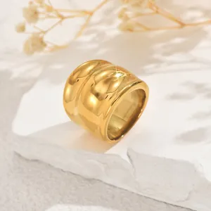 Primer plano de un anillo dorado pulido y grueso sobre una base de piedra natural
