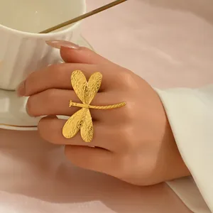 Exaggerated golden dragonfly open ring with textured wings worn on hand for women