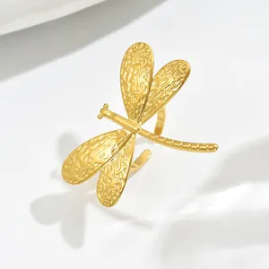Golden dragonfly open ring with hammered texture wings in a minimalist geometric design