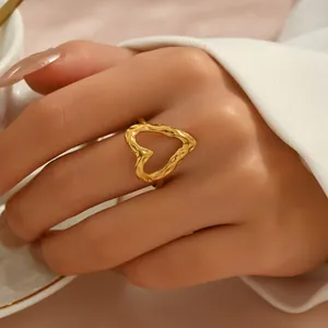 Elegant gold heart ring with hammered texture on a female finger in a lifestyle shot