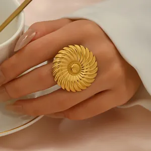 Vista dettagliata di un anello geometrico dorato oversize con trama a petali solari