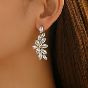 Luxurious marquise crystal flower cluster drop earrings in gold finish worn by a model