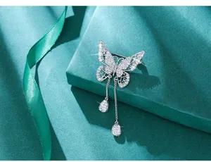Macro view of silver butterfly brooch with sparkling tassels and hollow wing details