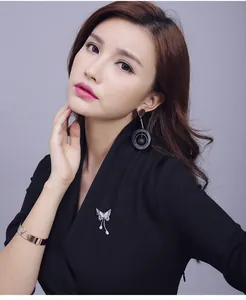 Elegant butterfly brooch with tassel and sparkling crystals on a black suit blazer