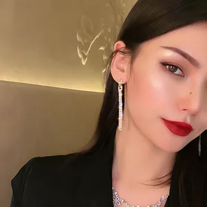 Elegant 925 silver long tassel earrings with sparkling crystals and gold finish on model