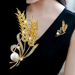 Elegante spilla a spiga di grano con zirconi gialli e perla bianca su abito