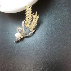Elegante spilla a spiga di grano con zirconi gialli e perla su base color oro