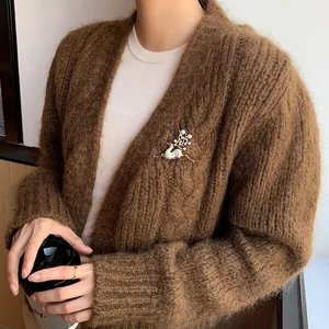Detailansicht einer Rentier-Brosche mit Perlen und Zirkonia auf einer Strickjacke