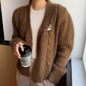 Exquisite goldene Elch-Brosche mit funkelndem Zirkon auf braunem Strick-Cardigan