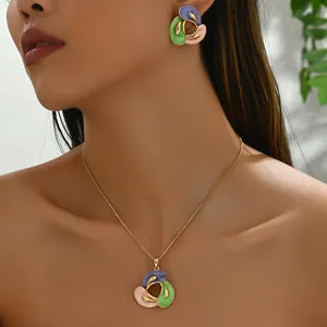 Parure de bijoux en émail tricolore avec collier et boucles d'oreilles portés sur modèle