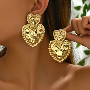 Chic 18K gold plated double heart earrings with hammered texture on female model