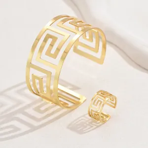 Dettaglio set di gioielli d'oro con motivo a meandro greco su anello e bracciale