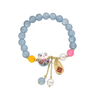 Minimalistisches Perlenarmband mit hellblauen Perlen und Keramik-Glückskatzen-Charm