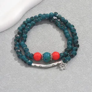 Detail of vintage double-layer beaded bracelet with blue floral patterns and metal charms
