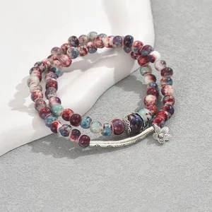 Retro double-layer beaded bracelet with ceramic stones and floral metal pendant