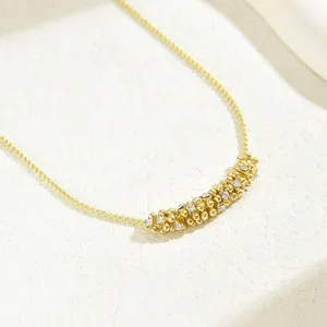 Elegant gold necklace with geometric beaded pendant featuring sparkling cubic zirconia crystals