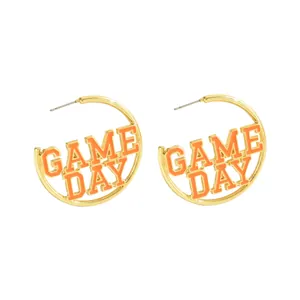 Golden round hoop earrings with orange enamel GAME DAY lettering for casual style
