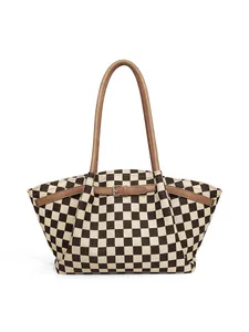 Detail of checkered hobo bag featuring brown leather straps and metallic buckle hardware